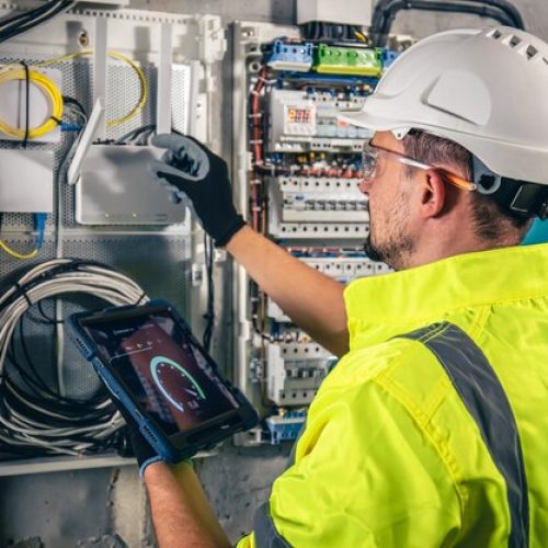 man-electrical-technician-working-switchboard-with-fuses-uses-tablet_169016-24811.jpg